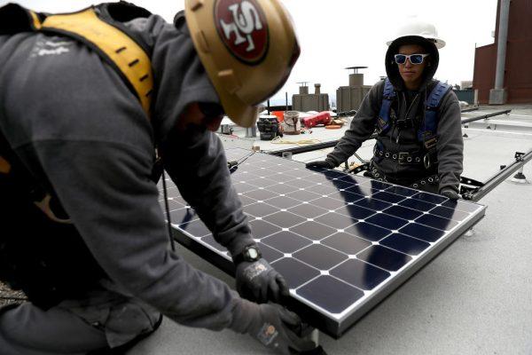 Technicians are installing solar panels on the roof of a home in San Francisco, Calif. on May 9, 2018. (Justin Sullivan/Getty Images)