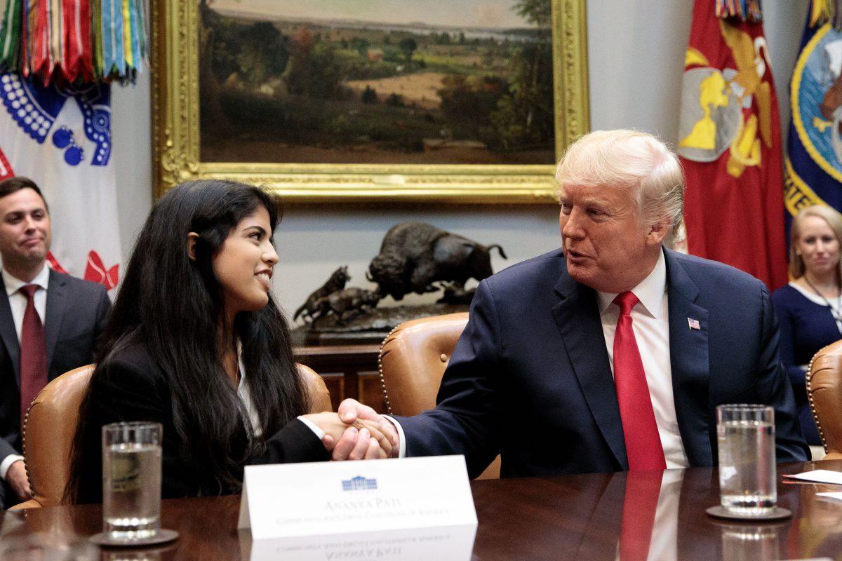 President Donald Trump shakes hands with Ananya Pati of the Community Anti-Drug Coalitions of America during an announcement for a grant for a drug-free communities support program. (Samira Bouaou/The Epoch Times)