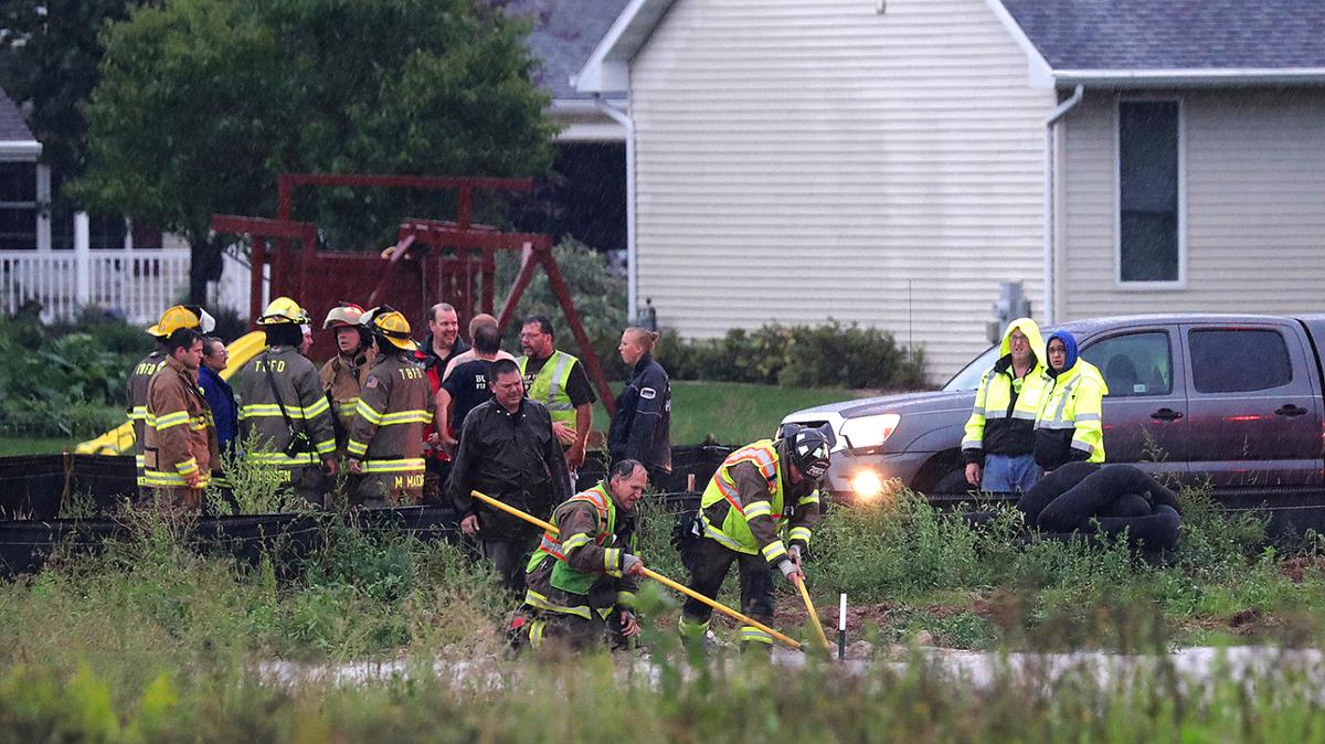 Emergency responders, police, and firefighters search for an 11-year-old boy who was sucked into a flooded storm sewer in Harrison, Wis., Aug. 28, 2018. (Wm. Glasheen/The Post-Crescent via AP)
