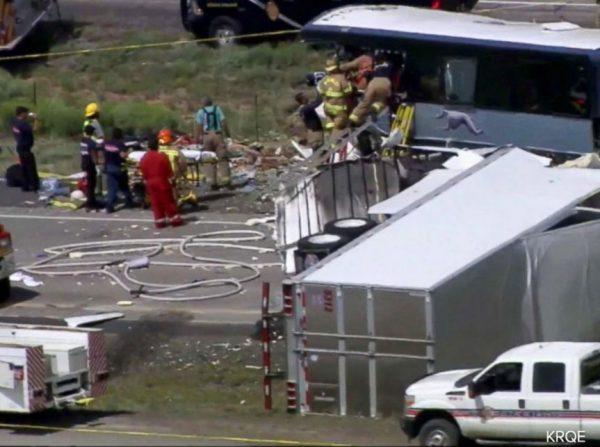 First responders working the scene of a collision between a Greyhound passenger bus and a semi-truck on Interstate 40 near the town of Thoreau, N.M., near the Arizona border, Thursday, Aug. 30, 2018. (KQRENews13 via AP)