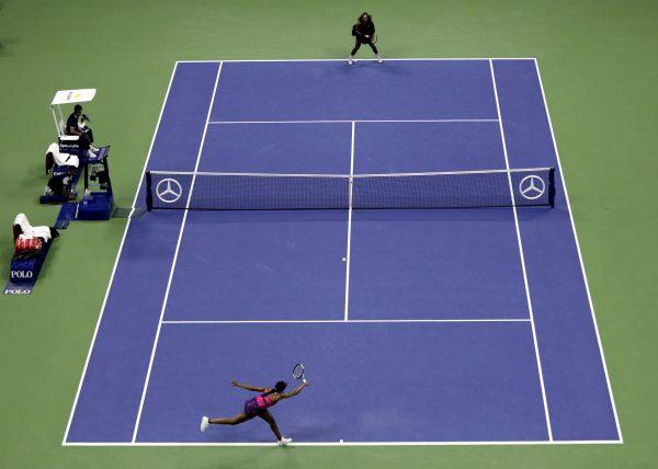 Venus Williams, bottom, returns a shot to Serena Williams during the third round of the U.S. Open tennis tournament in New York on Aug. 31, 2018, (AP Photo/Julio Cortez)