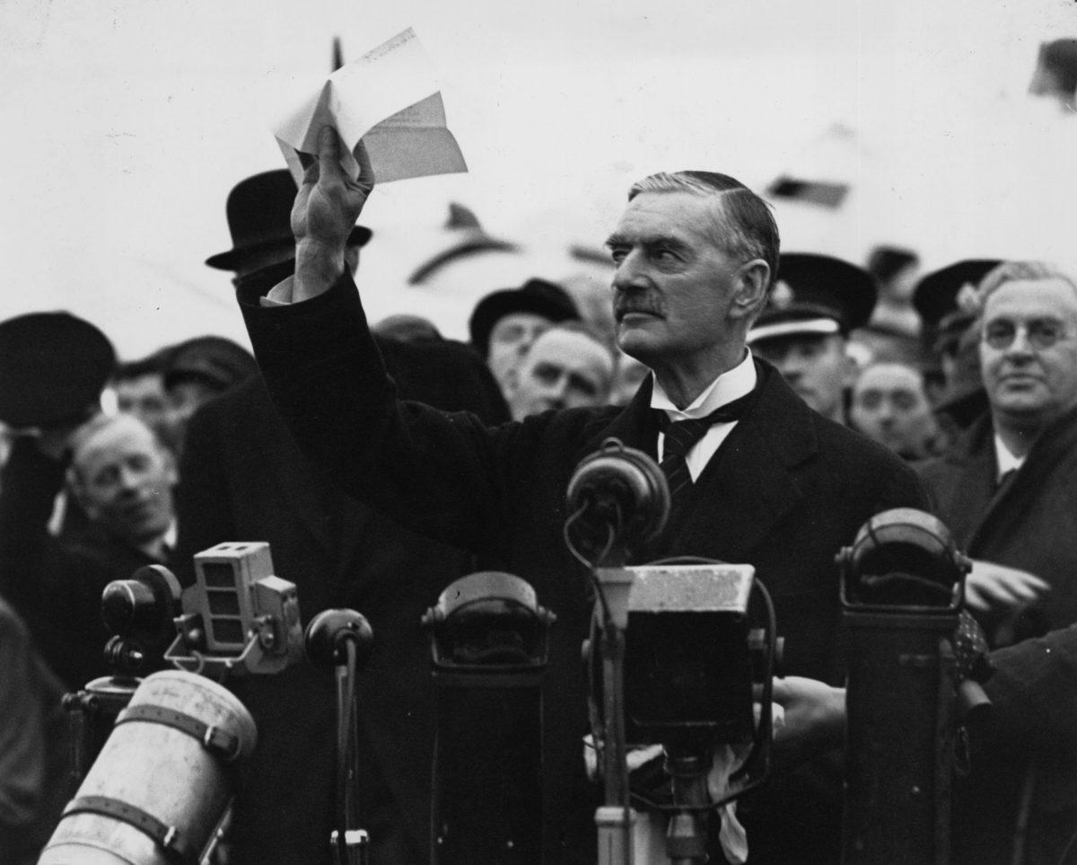 British statesman and prime minister Neville Chamberlain (1869 - 1940) at Heston Airport, west of London, on his return from Munich after meeting with Hitler, making his "peace in our time" address, on Sept. 30, 1938. (Central Press/Getty Images)