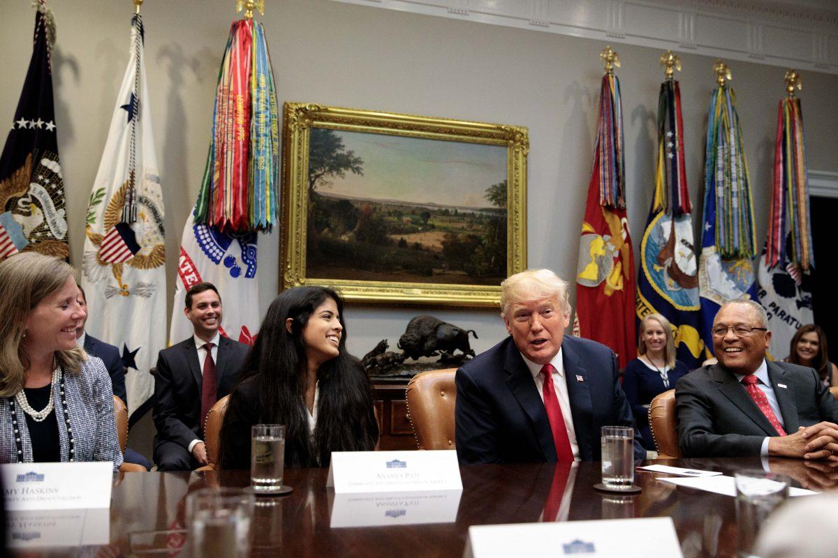 President Donald Trump, flanked by Ananya Pati (2nd L) of the Community Anti-Drug Coalitions of America and Arthur Dean (R), chairman and CEO of Community Anti-Drug Coalitions of America, makes a grant announcement for a drug-free communities support program, in the Roosevelt Room of the White House on Aug. 29, 2018. (Samira Bouaou/The Epoch Times)
