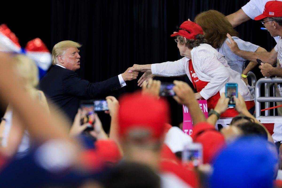 President Donald Trump shakes hands with an attendee at his Make America Great Again rally in Evansville, Ind., on Aug. 30, 2018. (Charlotte Cuthbertson/The Epoch Times)