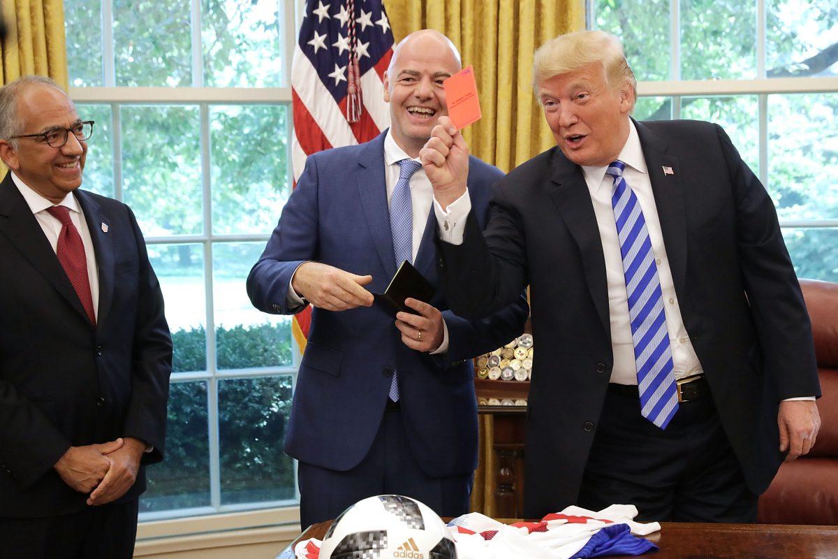 President Donald Trump pretends to give a red card to members of the media while meeting with FIFA President Gianni Infantino (C) and U.S. Soccer President Carlos Cordeiro (L) in the Oval Office on Aug. 28, 2018. (Chip Somodevilla/Getty Images)