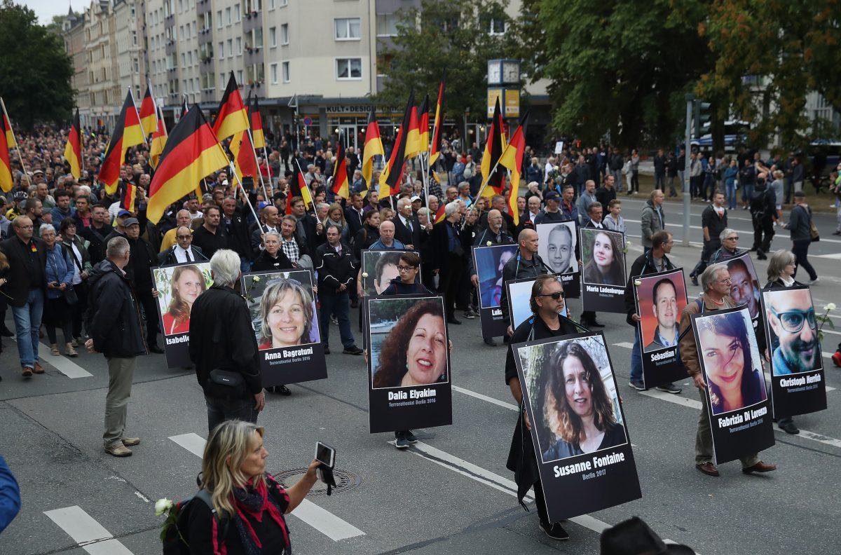 People take part in a march organised by the right-wing Alternative for Germany (AfD) political party and carry German flags and portraits of supposed victims of violence allegedly perpetrated by migrants. (Sean Gallup/Getty Images)