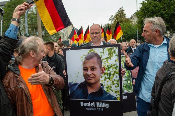 People take part in a march organized by the right-wing Alternative for Germany (AfD) political party and carry German flags and portraits of supposed victims of migrant violence on Sept. 1, 2018, in Chemnitz, Germany. (Jens Schlueter/Getty Images)
