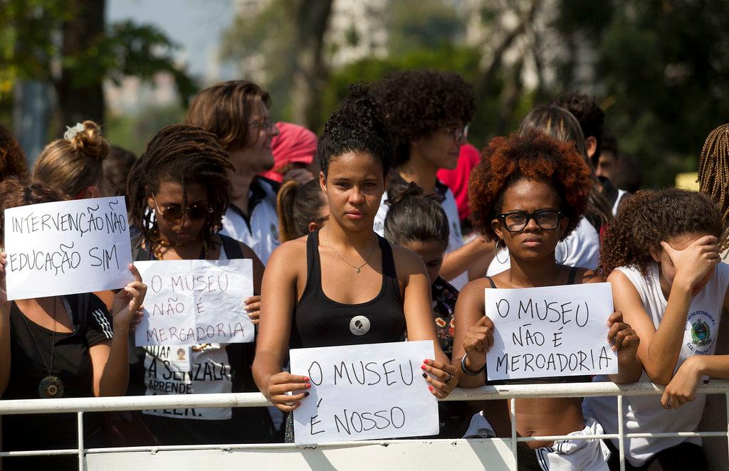 Students and National Museum personnel protest outside the museum which suffered an overnight fire in Rio de Janeiro, Brazil, Monday, Sept. 3, 2018. The signs in Portuguese read: "The museum is ours," and "The museum is not merchandise." Recriminations flew over who was responsible for a huge fire that destroyed of at least part of Latin America’s largest collection of historical artifacts and documents. (AP/Silvia Izquierdo)