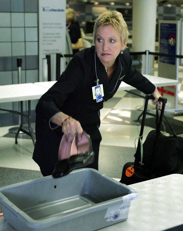 A United Airlines flight attendant drops her shoes into a plastic tray as she prepares to pass through a security checkpoint in the United Airlines terminal at O'Hare International Airport in Chicago, Illinois on May 11, 2005. (Tim Boyle/Getty Images)