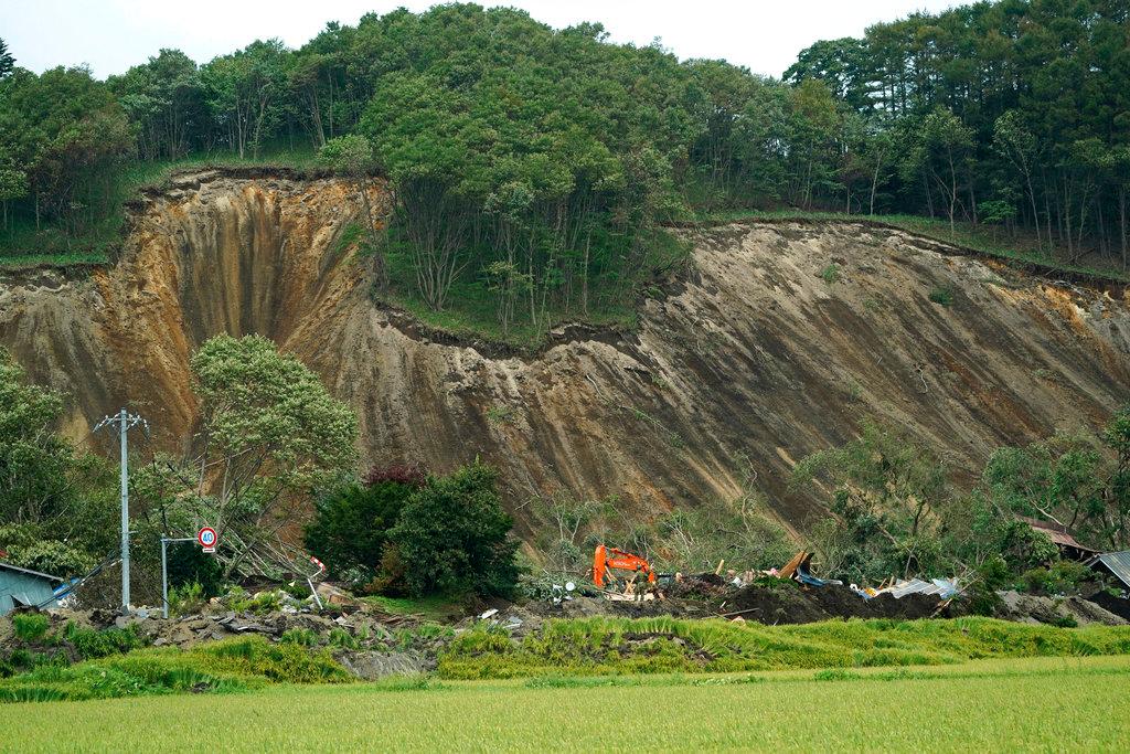 Police search missing persons at the site of a landslide triggered by an earthquake in Atsuma town, Hokkaido, northern Japan, on Sept. 7, 2018. (AP/Eugene Hoshiko)