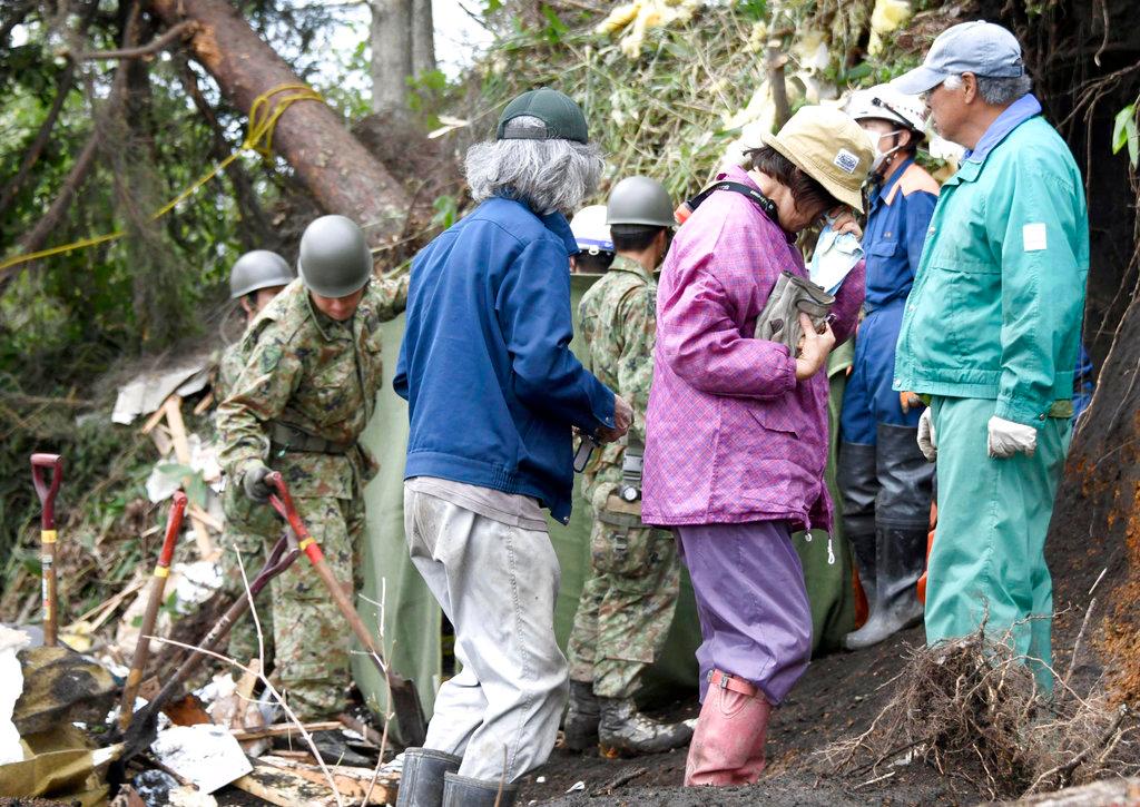A woman cries after her missing father was found at the site of a landslide triggered by an earthquake in Atsuma town, Hokkaido, northern Japan, Sept. 7, 2018. Rescuers were using dogs, backhoes and shovels to search Friday for survivors trapped in mud and debris from landslides triggered by a powerful earthquake in northern Japan. (Masanori Takei/Kyodo News/AP)