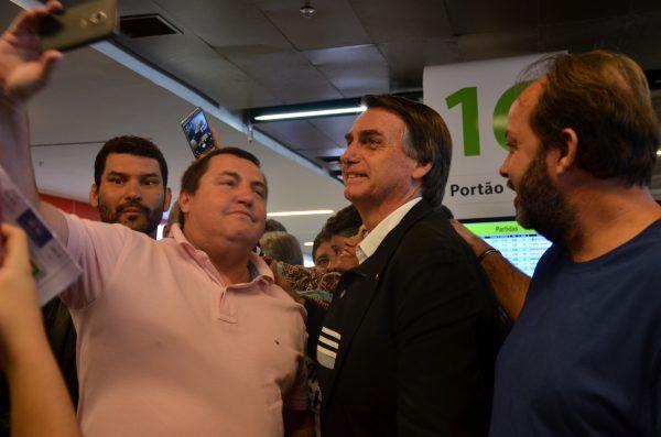 Brazilian presidential candidate Jair Bolsonaro poses for a selfie with a supporter in the Brasilia International Airport on Aug. 31, 2018.  (Sarita Reed/Special to The Epoch Times)