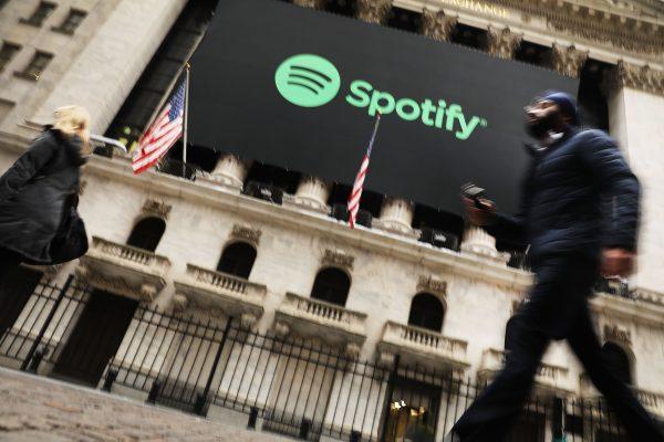 People walk by the New York Stock Exchange (NYSE) on the morning that the music streaming service Spotify begins trading shares at the NYSE in New York City on April 3, 2018. (Spencer Platt/Getty Images)