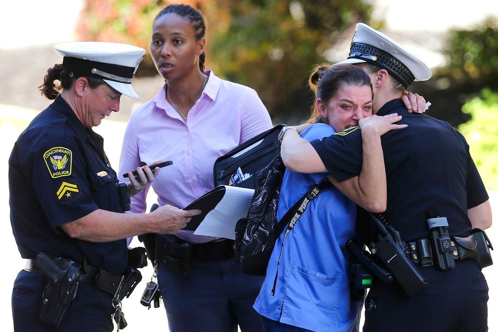A woman is comforted by authorities stationed outside the University of Cincinnati Medical Center's Emergency room following a shooting in downtown Cincinnati that left at least four dead, including the gunman, and several injured on Sept. 6, 2018. (Kareem Elgazzar/The Cincinnati Enquirer via AP)