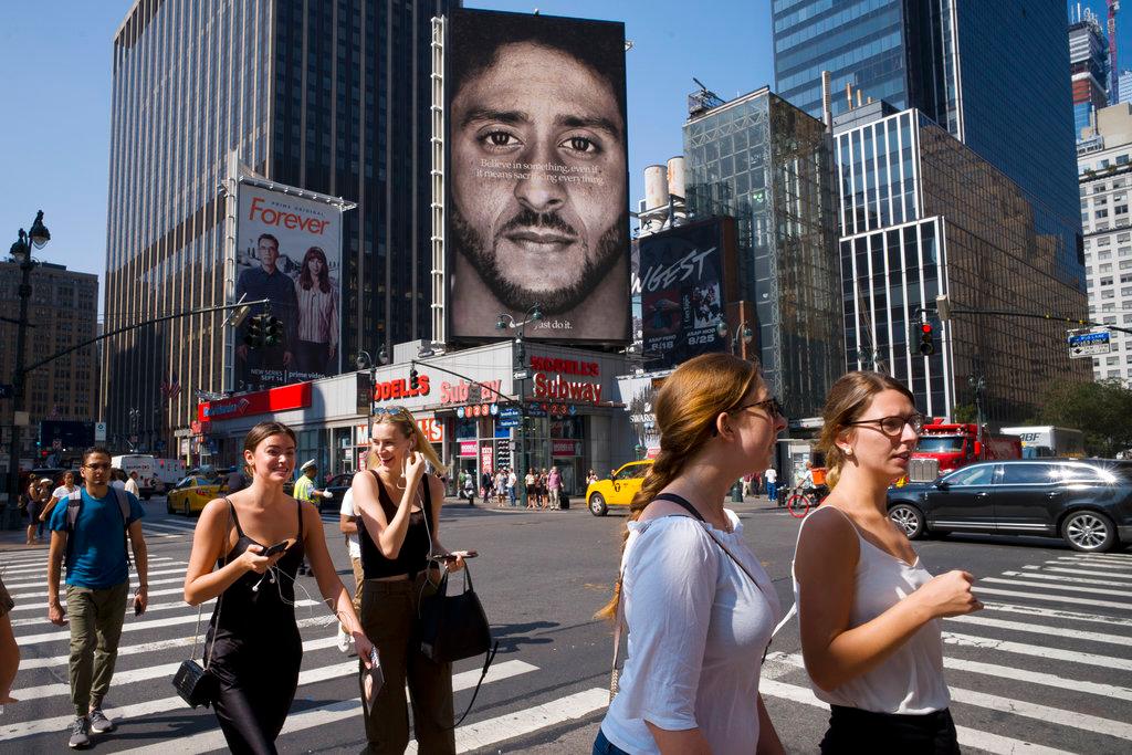 People walk by a Nike advertisement featuring Colin Kaepernick on display, Thursday, Sept. 6, 2018, in New York. Nike this week unveiled the deal with the former San Francisco 49ers quarterback, who's known for starting protests among NFL players over alleged police brutality and racial inequality. (AP Photo/Mark Lennihan)