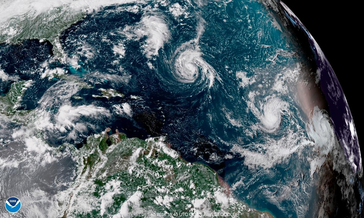 An enhanced satellite image shows Tropical Storm Florence, upper left, in the Atlantic Ocean. At center is Tropical Storm Isaac and at right is Hurricane Helene. The image is from Sept. 11, 2018. (NOAA via AP)