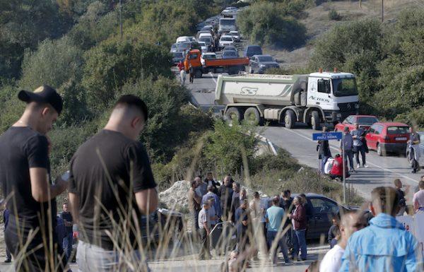 Trucks are parked on the road at a roadblock in Vojtesh, Kosovo, on Sept. 9, 2018. (AP Photo/Visar Kryeziu)
