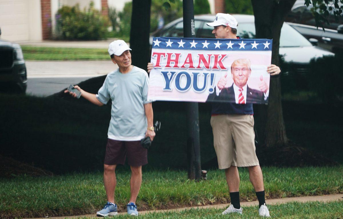 A Trump supporter holds up a placard as the motorcade carrying President Donald Trump enters the Trump National Golf Club in Sterling, Va., on Sept. 8, 2018. (MANDEL NGAN/AFP/Getty Images)