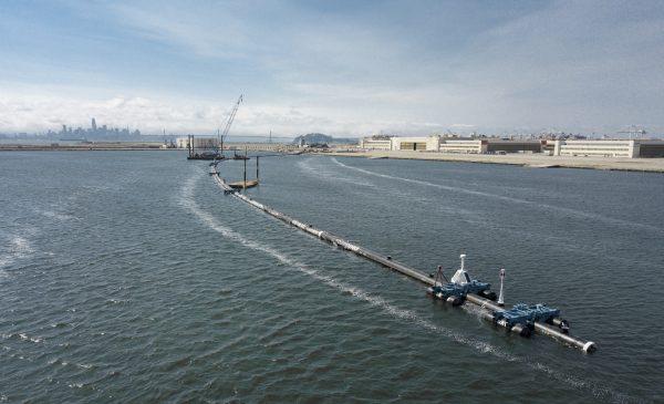 A long floating boom that will be used to corral plastic litter in the Pacific Ocean is assembled in Alameda, California on Aug. 27, 2018. (The Ocean Cleanup via AP)