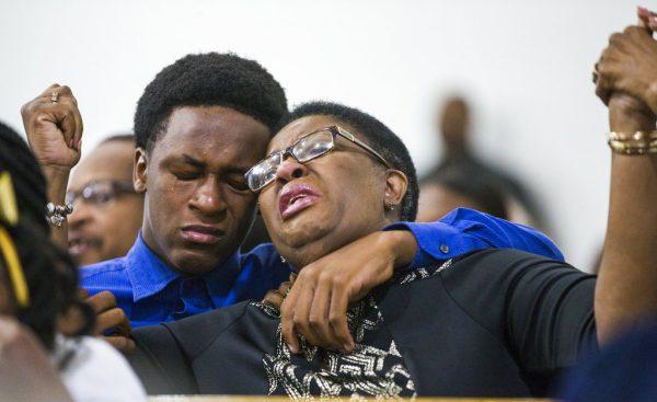 Allison Jean raises her hands in the air as she leans on her son, Grant, 15, during a prayer service for her son and Grant's brother Botham Jean at the Dallas West Church of Christ on Sept. 9, 2018, in Dallas. (Shaban Athuman/The Dallas Morning News/AP)