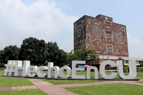 A young girl rests on a “Made in CU” (Ciudad Universitaria) sign in the shadow of the Biblioteca Central on Sept. 7, 2018, amid the calm of UNAM's main campus, just two days after a protest against university officials drew 30,000 people. (Tim MacFarlan/Special to The Epoch Times)