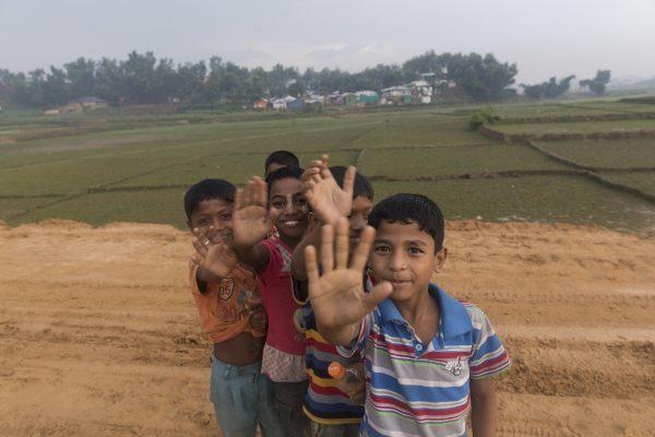 Children wave at the camera in Lombashia Camp, Cox’s Bazar, Bangladesh, on May 19, 2018. (Aungmakhai Chak/DEC)
