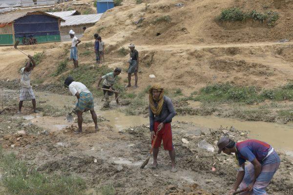 People dig trenches to direct rainwater from the upcoming monsoon season through the camp in Balukhali-1 Camp, Cox’s Bazar, Bangladesh, on May 21, 2018. (Aungmakhai Chak/DEC)
