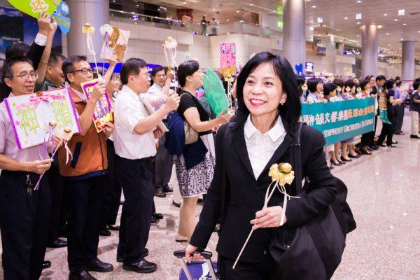 Li Chia-Chi, a violinist with Shen Yun Symphony Orchestra, walks past welcoming fans at the Taoyuan International Airport in Taoyuan, Taiwan, on Sept. 12, 2018. (Chen Po-chou/The Epoch Times)