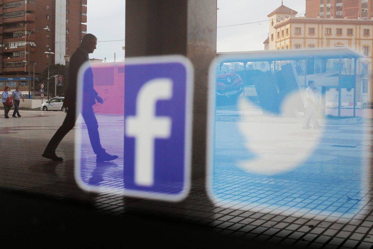 Facebook and Twitter logos are seen on a shop window in Malaga, Spain on June 4, 2018. (Jon Nazca/Reuters)