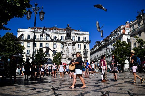 Pigeons fly over tourists gathering at Camoes square, Lisbon, on Aug. 2, 2017. (Patricia De Melo Moreira/AFP/Getty Images)