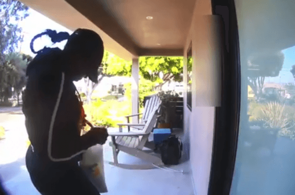 A female suspect knocks at the front door of a house before other burglars break in the back in Mar Vista, Calif. in a video released by LAPD on Sept. 11, 2018. (Screenshot/LAPD)