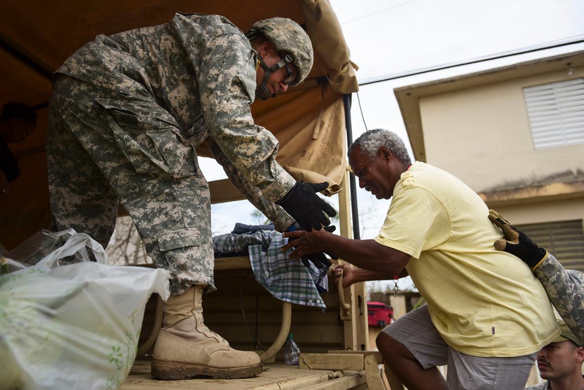 National Guard personnel evacuate Toa Ville resident Luis Alberto Martinez after the passing of Hurricane Maria, in Toa Baja, Puerto Rico on Sept. 22, 2017. (AP Photo/Carlos Giusti)