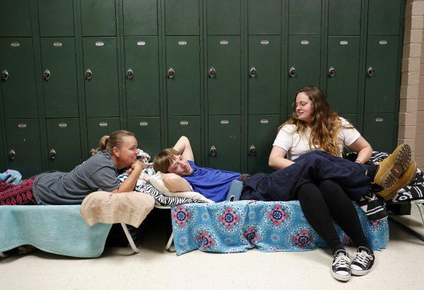 A mother sits with her son and his girlfriend in a shelter, waiting for Hurricane Florence to pass after evacuating from their nearby homes, in Conway, S.C. on Wednesday, Sept. 12, 2018. (AP Photo/David Goldman)