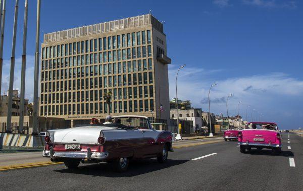 Tourists ride classic convertible cars on the Malecon beside the United States Embassy in Havana, Cuba, on Oct. 3, 2017. (AP Photo/Desmond Boylan,)