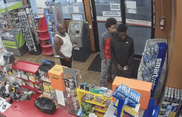 A man and two teenagers look at a store clerk who collapsed on the floor in Auburn, Wash. on Sept. 8, 2018. (Screenshot/Auburn Police Department).