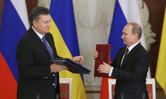 Russia's President Vladimir Putin (R) and his Ukrainian counterpart Viktor Yanukovych exchange documents at a signing ceremony after a meeting at the Kremlin in Moscow, on Dec. 17, 2013. (Sergei Karpukhin/File Photo/Reuters)