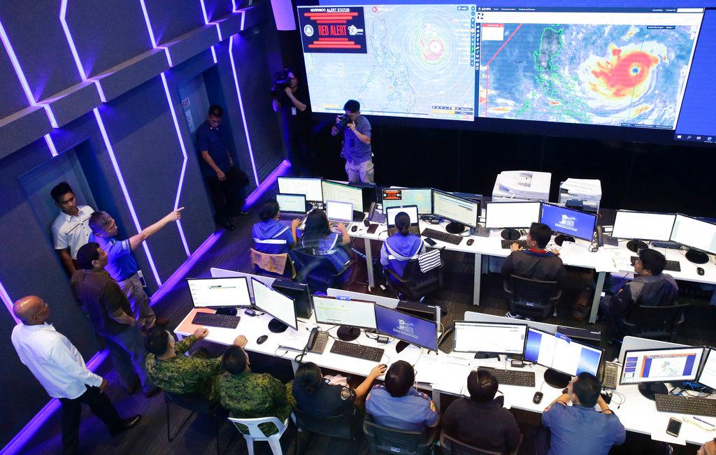 Philippine President Rodrigo Duterte, second from left, observes the National Disaster Risk Reduction and Management Council operation center in metropolitan Manila, Philippines on Sept. 13, 2018. The Philippine officials have begun evacuating thousands of people in the path of the most powerful typhoon this year, closing schools and readying bulldozers for landslides. (Aaron Favila/AP Photo)