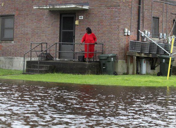 Residents at Trent Court Apartments wait out the weather as rising water gets closer to their doors in New Bern, N.C., on Sept. 13, 2018. (Gray Whitley/Sun Journal via AP)