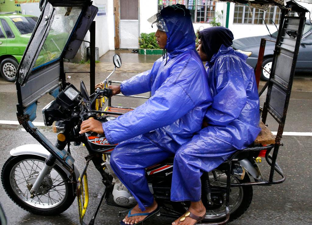 Residents wear raincoats during rain as Typhoon Mangkhut nears Tuguegarao, Cagayan province, northeastern Philippines Sept. 14, 2018. Typhoon Mangkhut retained its ferocious strength and slightly shifted toward more densely populated coastal provinces on Sept. 14 as it barreled closer to the northeastern Philippines, where a massive evacuation was underway. (Aaron Favila/AP Photo)