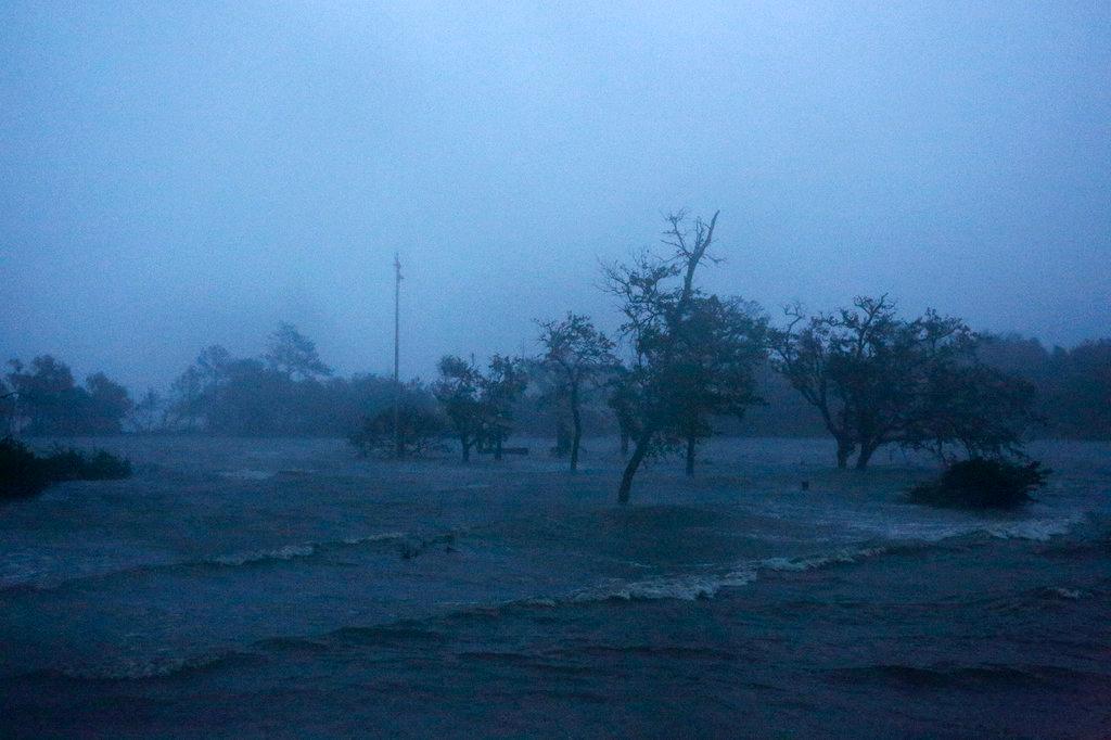 Before sunrise, high winds and storm surge from Hurricane Florence hits Swansboro N.C., on Sept. 14, 2018. (AP Photo/Tom Copeland)