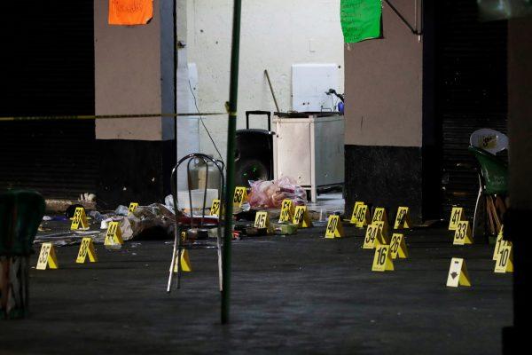 Evidence markers are seen at a crime scene where three men were gunned down by unknown assailants at an intersection on the edge of tourist Plaza Garibaldi in Mexico City, Mexico September 14, 2018. (Reuters/Henry Romero)