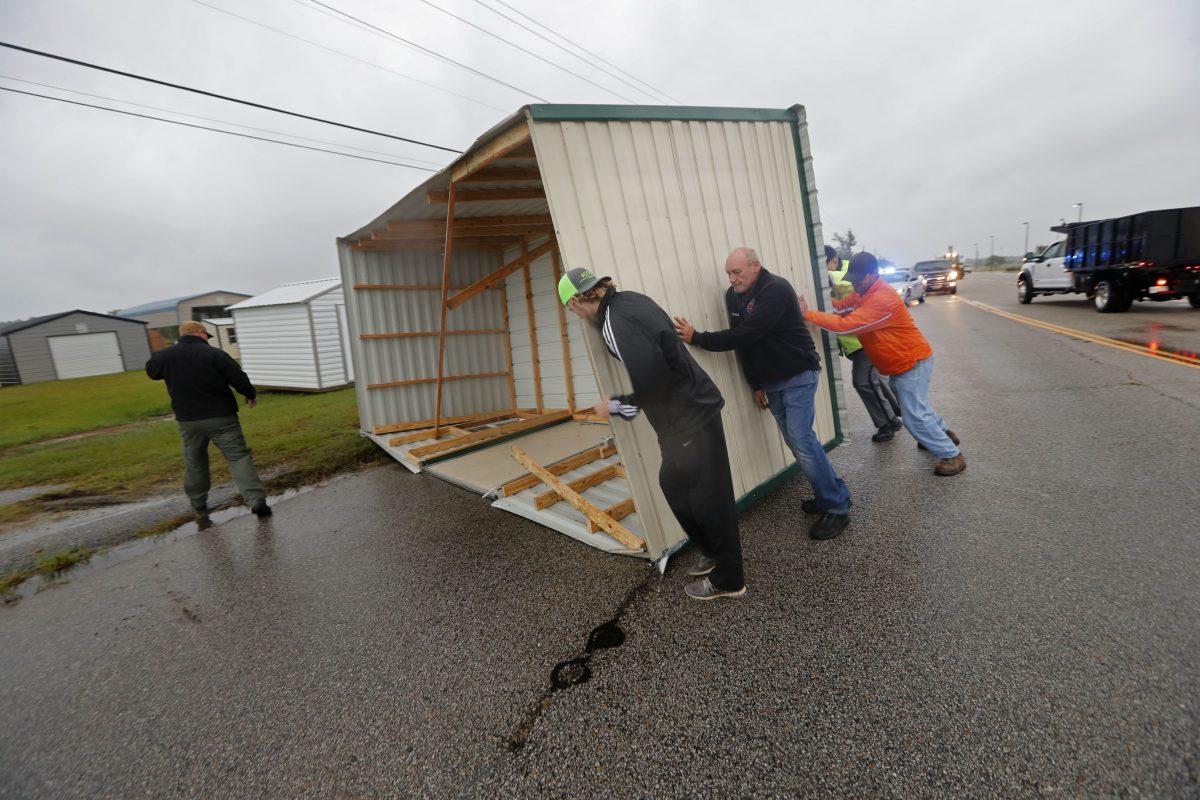 People move a wood and metal structure off a roadway after winds from Hurricane Florence blew it off a sales lot in Florence, S.C., Sept. 14, 2018. (Gerald Herbert/AP Photo)