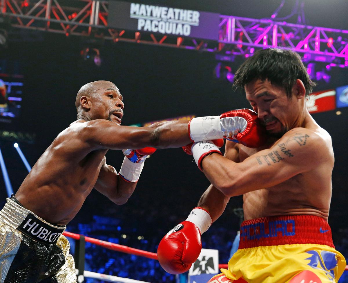 Floyd Mayweather Jr. (L) connects with a right to the head of Manny Pacquiao, from the Philippines, during their welterweight title fight in Las Vegas, on May 2, 2015. (AP Photo/John Locher, File)