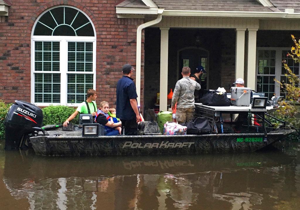 Authorities evacuate a family from rising waters caused by Florence, now a tropical storm in New Bern, N.C., on Sept. 15, 2018. (AP Photo/Allen G. Breed)