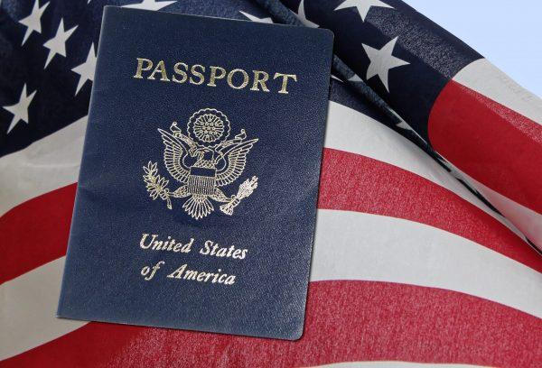 A United States passport is pictured with the country's flag. (Public Domain)