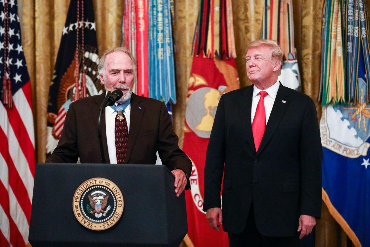 Vietnam veteran and Medal of Honor recipient Major Drew Dix speaks as President Donald Trump looks on at the Congressional Medal of Honor Society Reception in the East Room at the White House in Washington on Sept. 12, 2018. (Samira Bouaou/The Epoch Times)