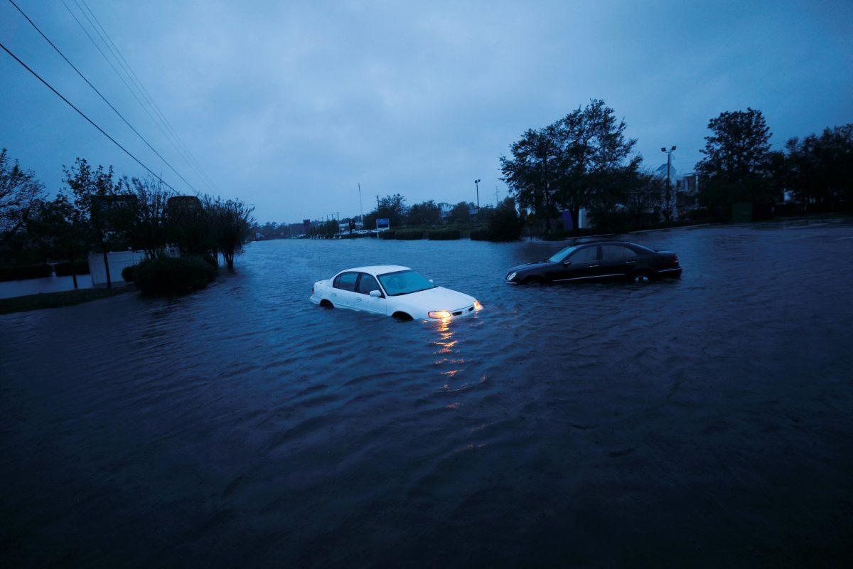 An abandoned car's hazard lights continue to flash as it sits submerged in rising floodwaters during pre-dawn hours after Hurricane Florence struck in Wilmington, N.C., on Sept. 15, 2018. (Jonathan Drake/Reuters)