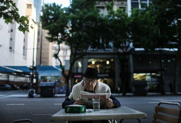 A man reads a newspaper at a cafe in Buenos Aires, Argentina on November 20, 2015. (Mario Tama/Getty Images)