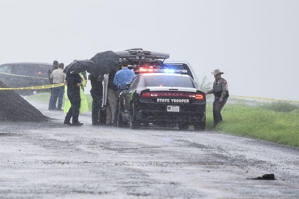 Law enforcement officers gather near the scene where the body of a woman was found near Interstate 35 north of Laredo, Texas on Sept. 15, 2018. (Danny Zaragoza/The Laredo Morning Times via AP)
