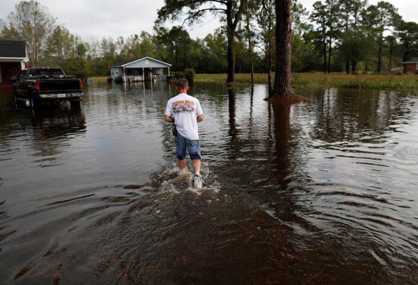 Members of the Marion Rural Fire Department carry supplies to a homeowner flooded after Tropical Storm Florence in Marion, South Carolina, on Sept. 17, 2018. (Randall Hill/Reuters)